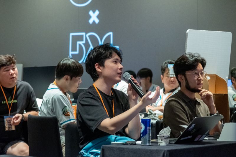 노트북을 앞에 두고 마이크로 질문하는 GS 해커톤 참가자